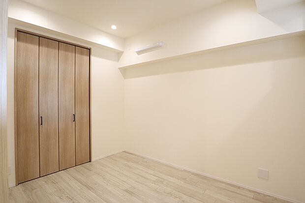 白を基調とした清潔感のある明るい洋室。木目調の建具がアクセントになり、暖かみをプラスしています。