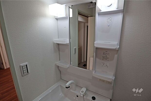 洗面室。鏡横の収納が豊富です。コンセントがあり、身支度に便利です。