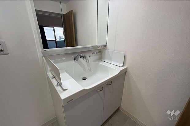洗面台は、三面鏡になっています。横に物置スペースがあるため、毎朝の身支度が楽になります。