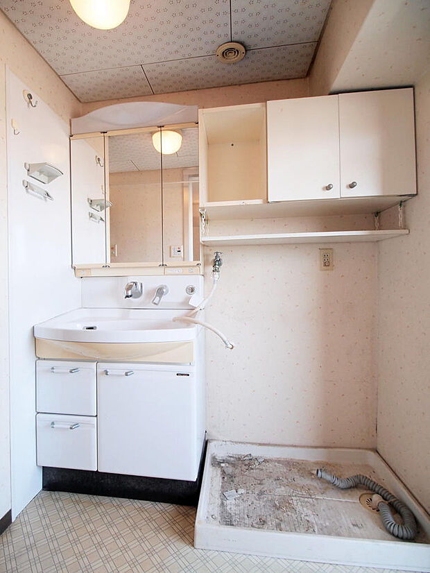 【洗面室】白でまとめられた洗面室です。洗濯機置き場の上部には、洗剤等を置くのに便利な収納スペースが備わっています。
