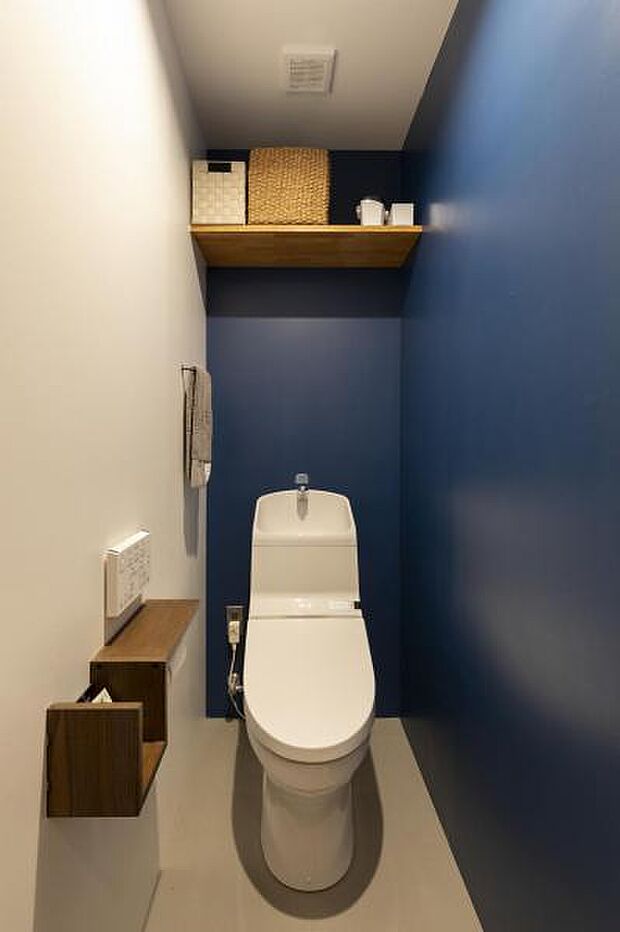 トイレの壁にはネイビーの塗装が施された、遊び心ある水回りスペースです。