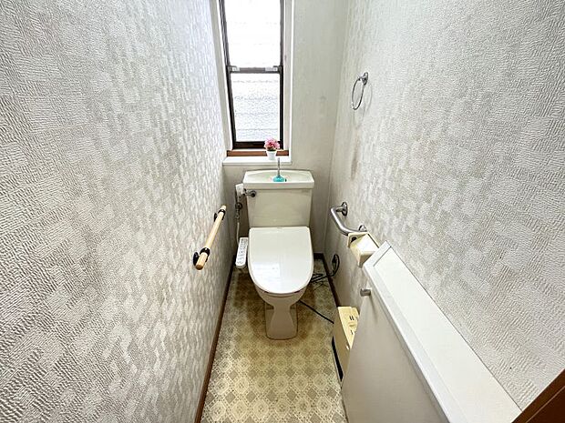 白を基調とした清潔感あるトイレ。棚がありトイレ用品を隠すことができます。
