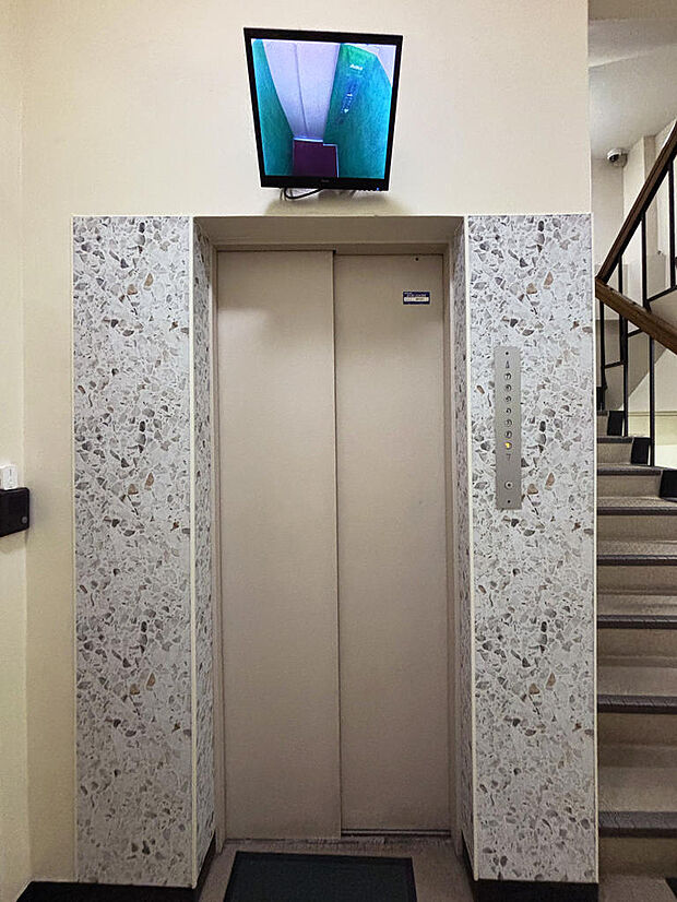 防犯カメラのモニターが映し出されているエレベーターホール