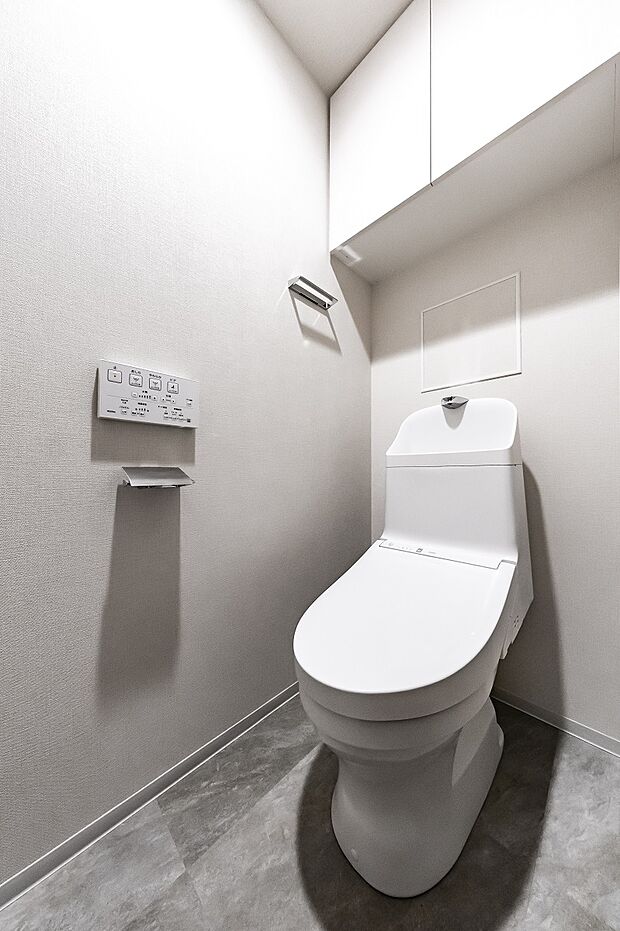 温水洗浄便座付きのトイレは清潔感がございます。スペースを有効活用した上部吊戸棚を採用。