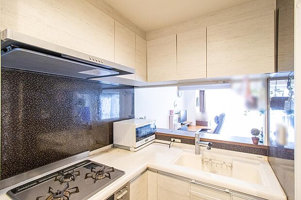 L字型のキッチンは、限られた空間の中で最大限の作業スペースを確保する工夫の成果です。吊戸棚も含めて多めに収納を確保。使い勝手の良いキッチンになっています。