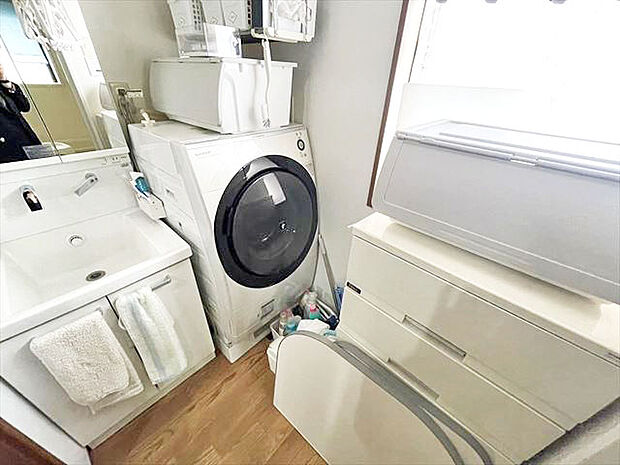 ホワイトで統一された洗面台。洗濯機上には収納力もあり、いつでもすっきりとした洗面室に。