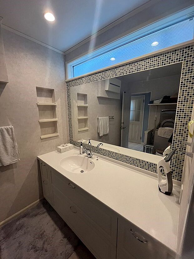 大きな鏡と周りのタイルが特徴的な大型洗面台。