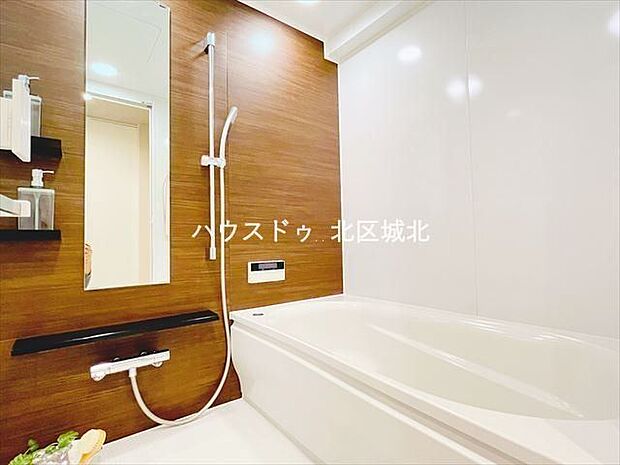 木目調の壁で暖かみのある浴室。