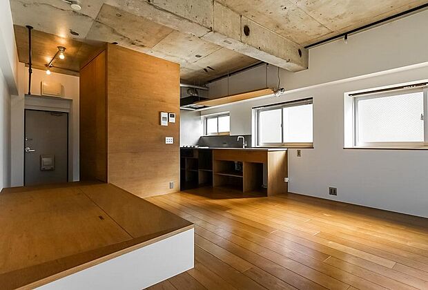 手前には小上がりのベッドスペース、奥にはキッチンが造作されています。木×白×コンクリートの絶妙なバランス。