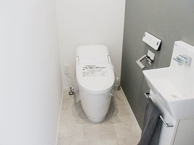 トイレもグレー基調のアクセントカラー、スタイリッシュなペーパーホルダーがポイント。