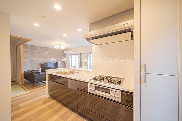 光沢のある扉デザインがキッチンを高級感のある空間へ。人造大理石の調理台はデザイン性はもちろんお掃除もしやすくおすすめです。